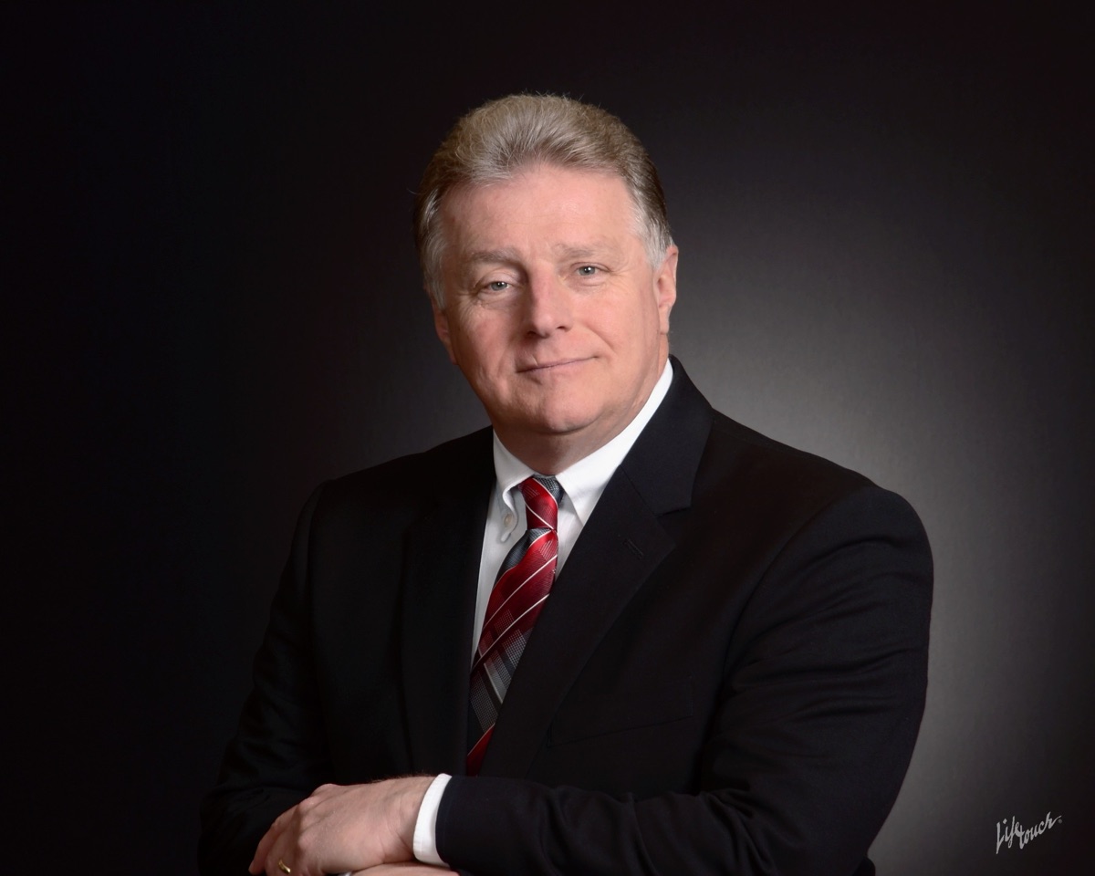 Wendell Rummage, real estate agent with Lantern Realty & Development, in a dark suit and red tie